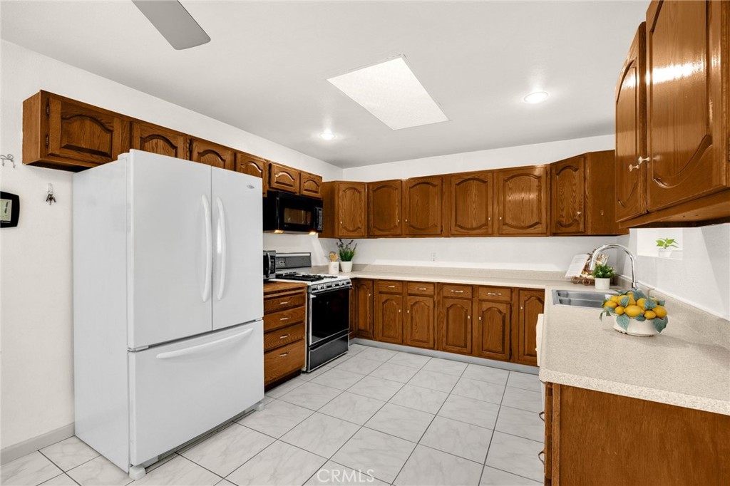 14721 Riata Street Midway City, CA 92655 - Photo 6 of 37 a kitchen with granite countertop stainless steel appliances and wooden cabinets