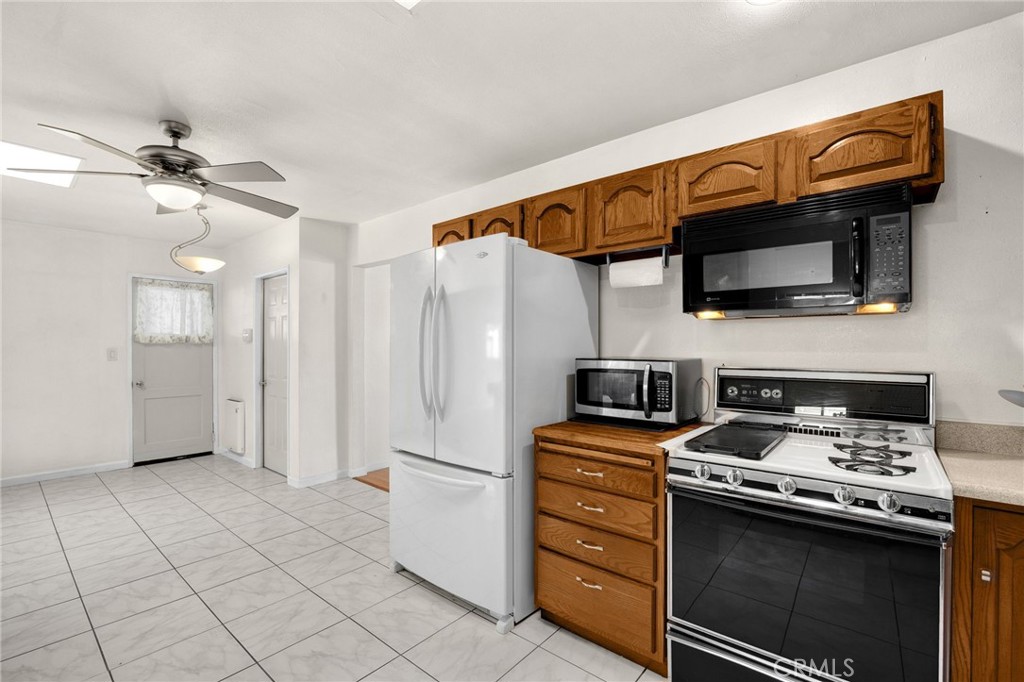 14721 Riata Street Midway City, CA 92655 - Photo 9 of 37 a kitchen with stainless steel appliances a stove a microwave and a refrigerator