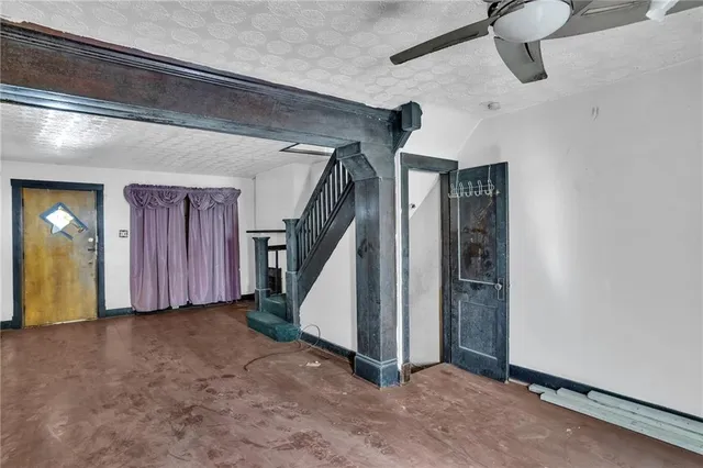 an empty room with windows and fireplace