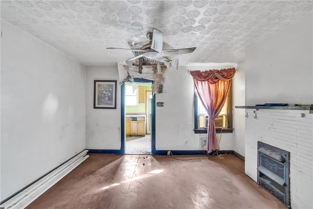 1616 Montier Street Pittsburgh, PA 15221 - Photo 9 of 22 an empty room with windows and fireplace