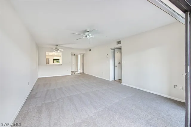 an empty room with windows and cabinet