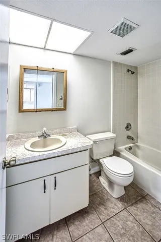 a bathroom with a granite countertop toilet sink and mirror