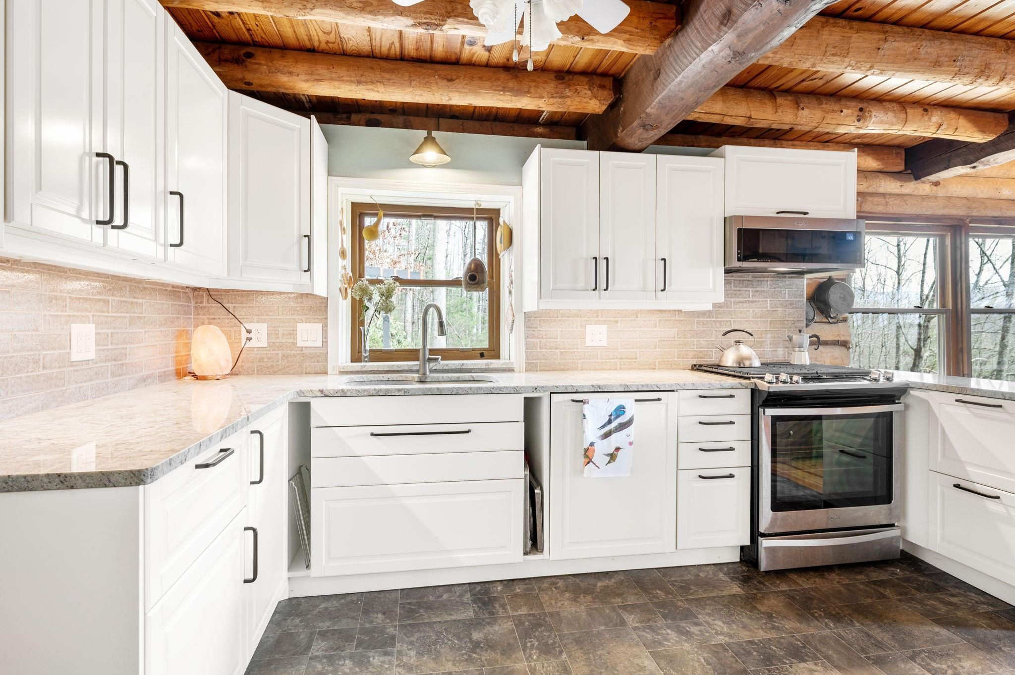 25 Dycus Drive Fairview, NC 28730 - Photo 9 of 30 a kitchen with stainless steel appliances granite countertop a stove and cabinets