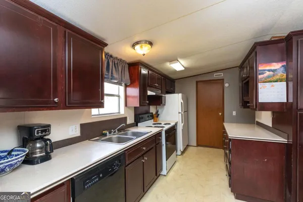 a kitchen with stainless steel appliances granite countertop a sink stove and cabinets