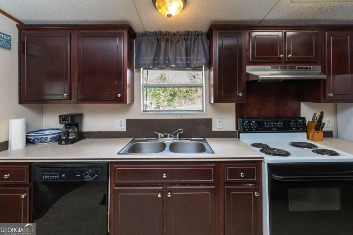 3547 Chapel Lane Blackshear, GA 31516 - Photo 12 of 33 a kitchen with stainless steel appliances granite countertop a sink stove and cabinets