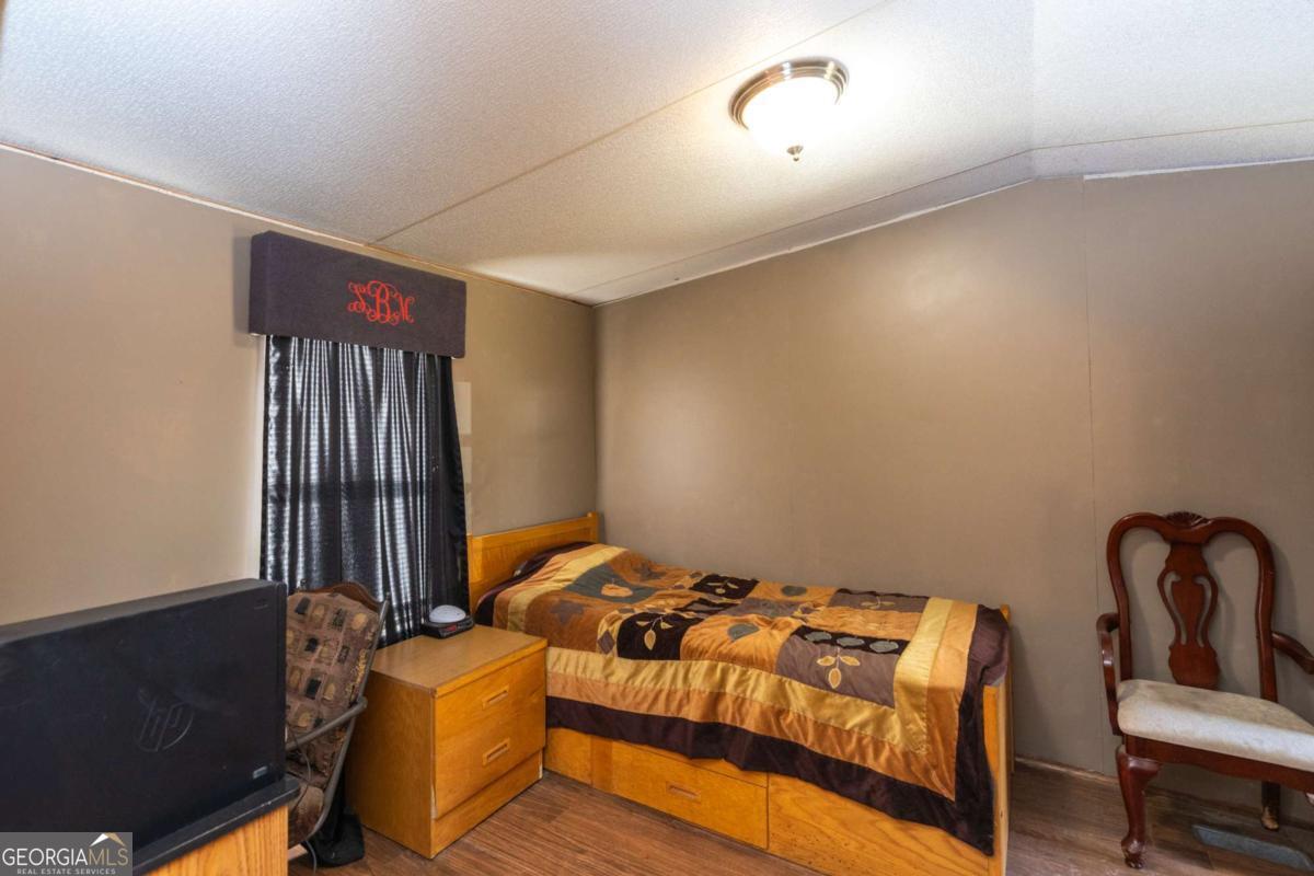 3547 Chapel Lane Blackshear, GA 31516 - Photo 19 of 33 a bedroom with a bed and chair