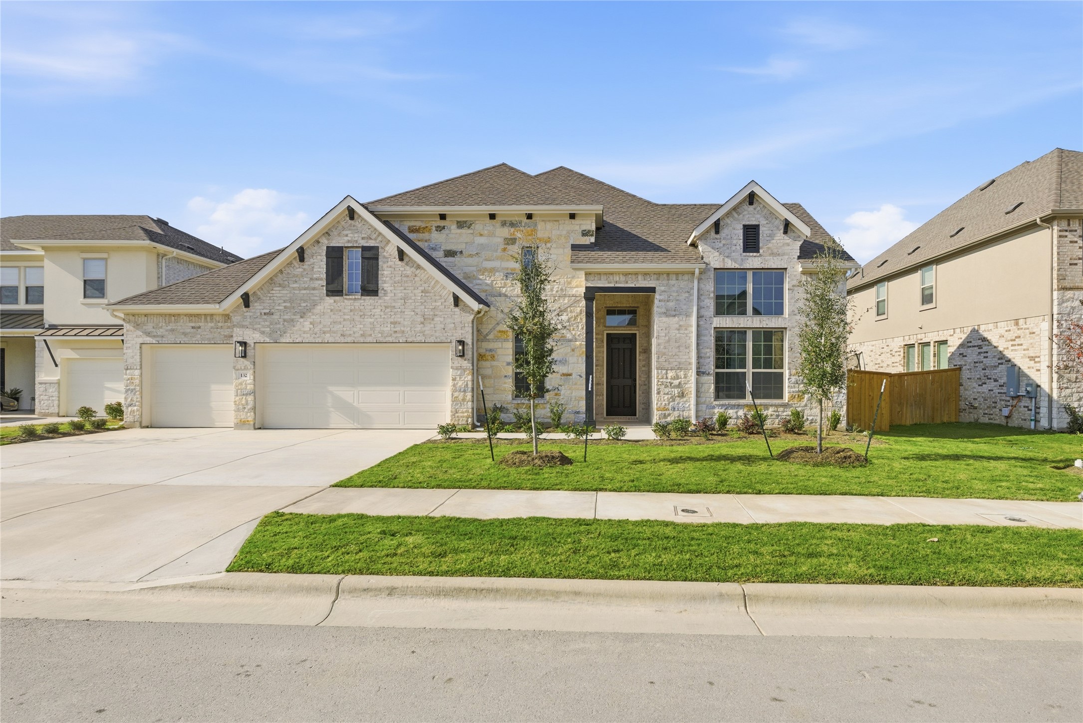 View of front of house featuring stone siding, concrete driveway, and a garage