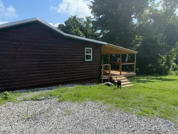 a backyard of a house with lots of green space and fountain