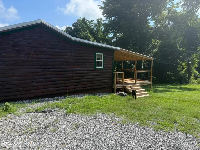 a backyard of a house with lots of green space and fountain