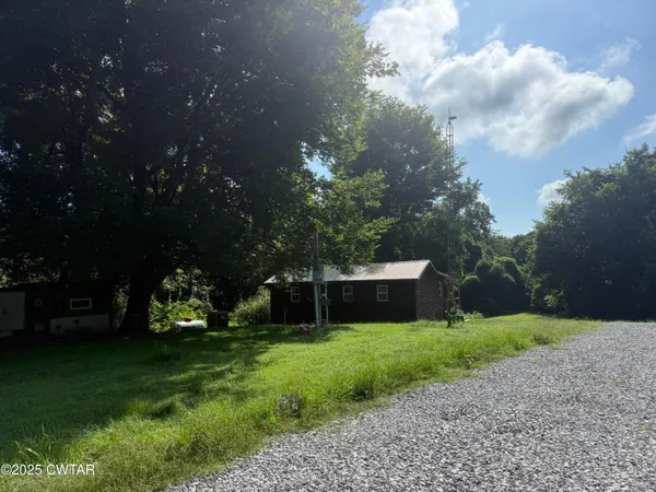 a backyard of a house with lots of green space and fountain