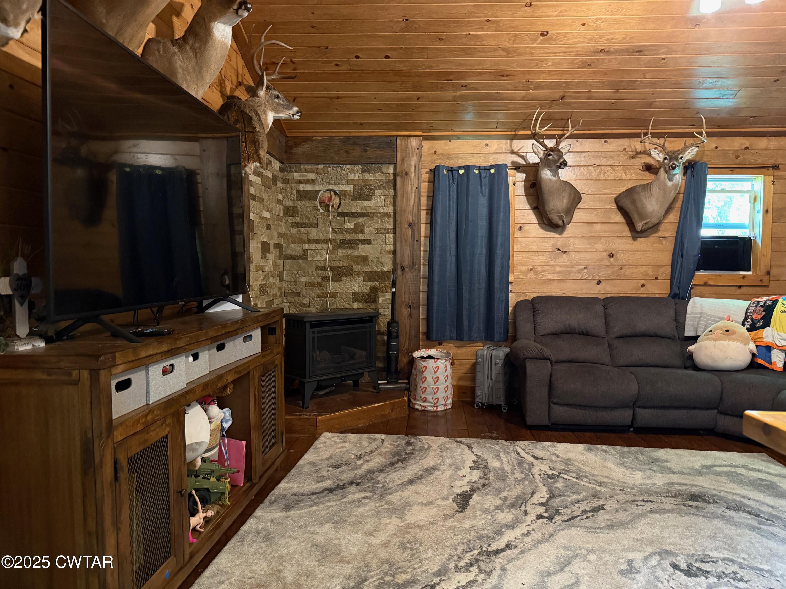 972 Cleve Duke Road Hornbeak, TN 38232 - Photo 5 of 36 a living room with furniture a flat screen tv and a fireplace