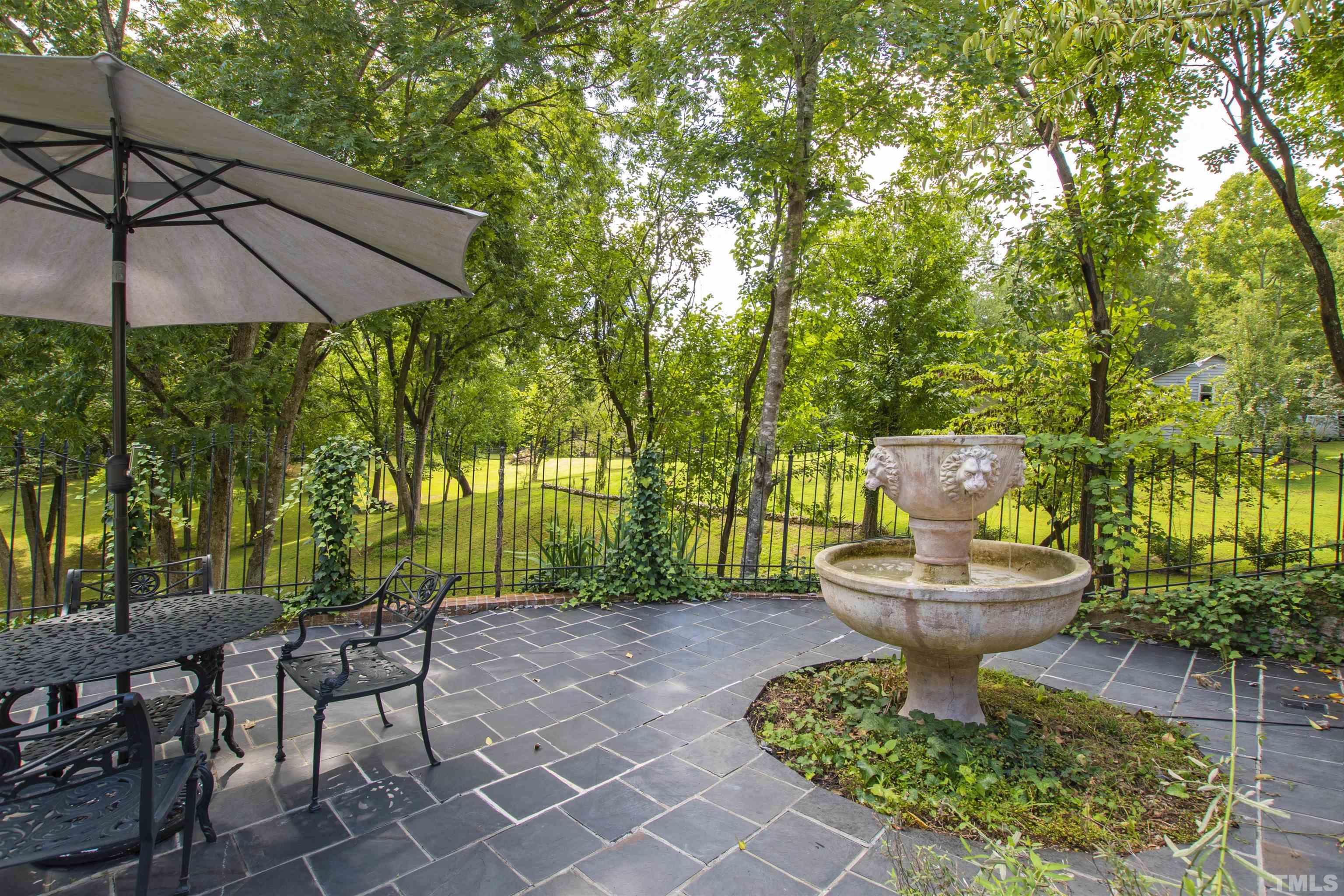 2429 Kirks Ridge Drive Raleigh, NC 27606 - Photo 6 of 65 a view of a patio with table and chairs under an umbrella