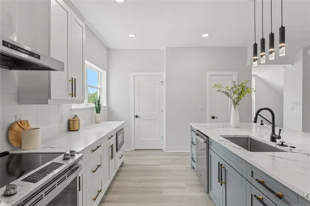 a kitchen with sink a stove and cabinets