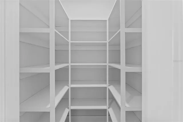 a view of walk in closet with empty racks