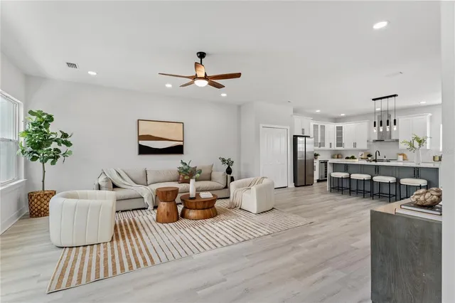 a living room with furniture kitchen view and a potted plant