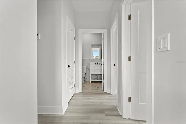 a view of a hallway with wooden floor and closet