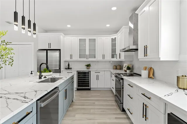 a kitchen with stainless steel appliances granite countertop a sink stove and refrigerator