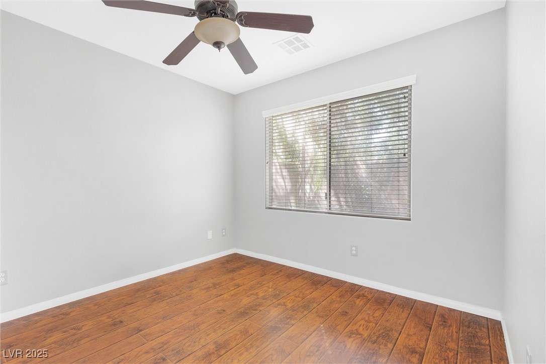 9617 Sharp Horn Court Las Vegas, NV 89149 - Photo 12 of 27 Unfurnished room featuring hardwood / wood-style flooring, baseboards, ceiling fan, and visible vents