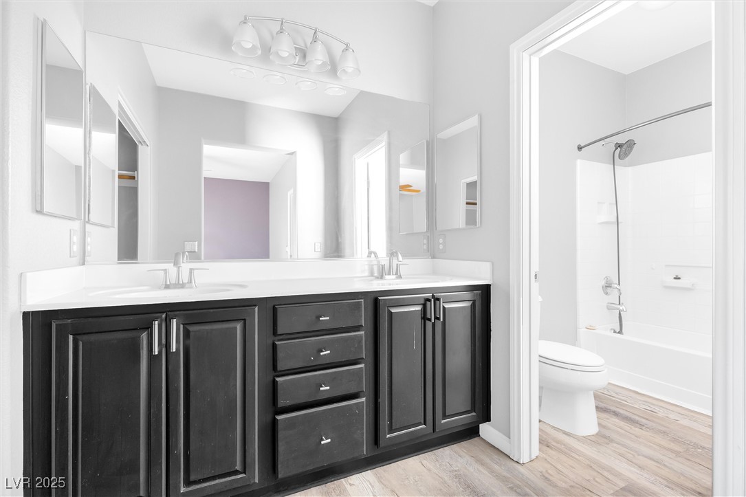 9617 Sharp Horn Court Las Vegas, NV 89149 - Photo 22 of 27 Full bath featuring toilet, a sink, double vanity, and wood finished floors