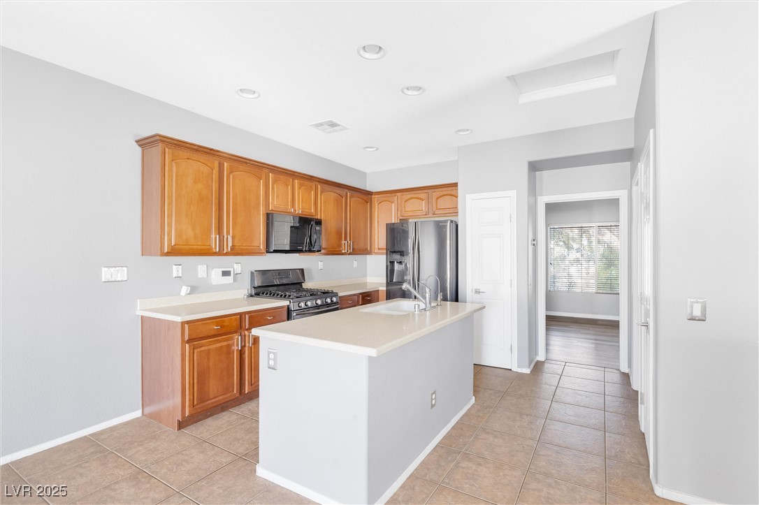 9617 Sharp Horn Court Las Vegas, NV 89149 - Photo 4 of 27 Kitchen with light countertops, a sink, stainless steel appliances, and visible vents