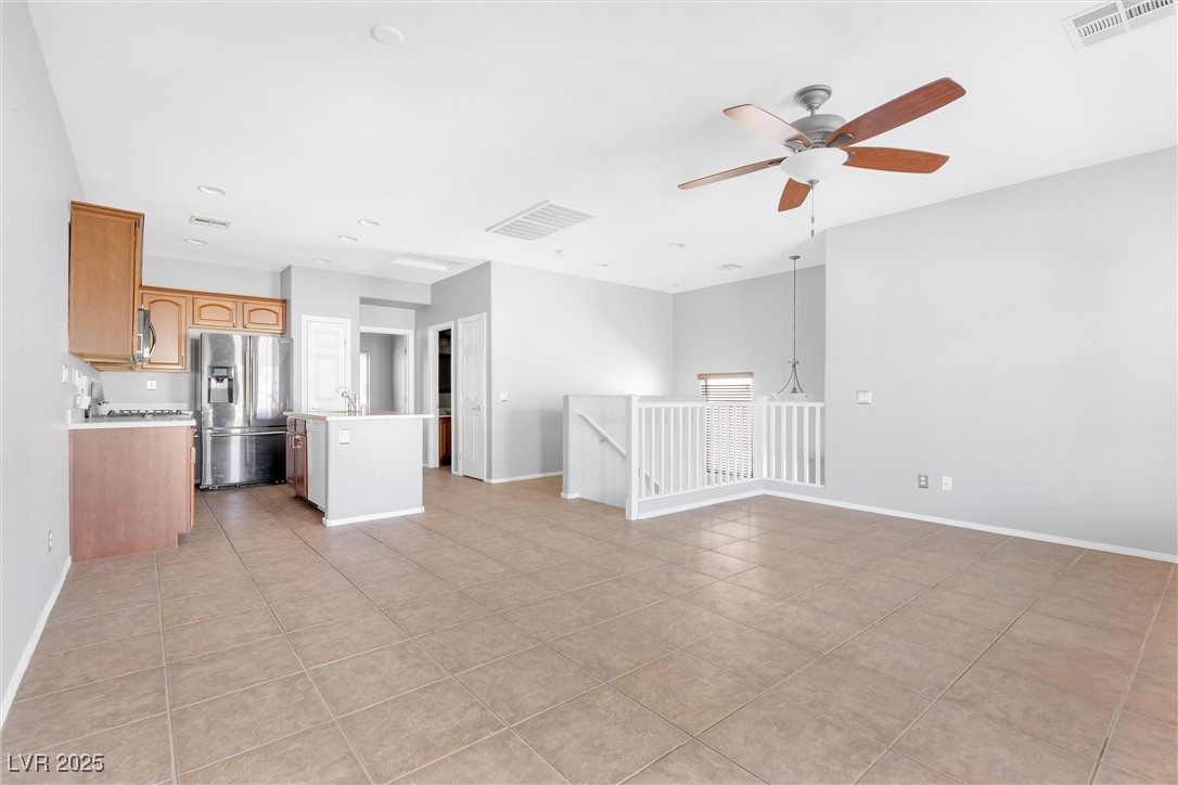 9617 Sharp Horn Court Las Vegas, NV 89149 - Photo 5 of 27 Unfurnished living room featuring light tile patterned floors, visible vents, baseboards, and ceiling fan
