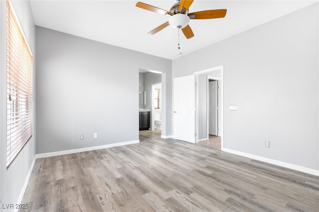 9617 Sharp Horn Court Las Vegas, NV 89149 - Photo 10 of 27 Unfurnished bedroom featuring light wood finished floors, baseboards, ensuite bathroom, and a ceiling fan