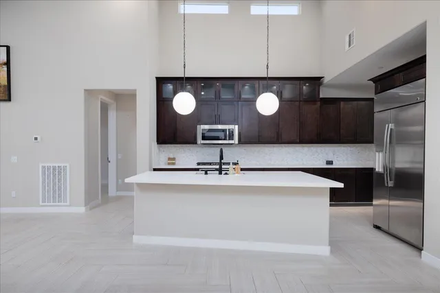 a kitchen with a sink and a large mirror with wooden floor