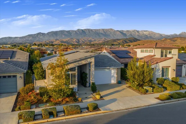 an aerial view of residential houses with outdoor space and trees