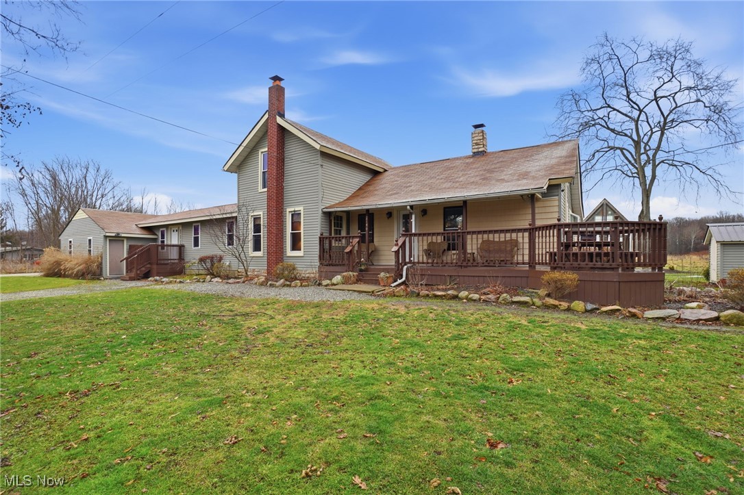 View of front of house with a chimney, a front lawn, and a porch