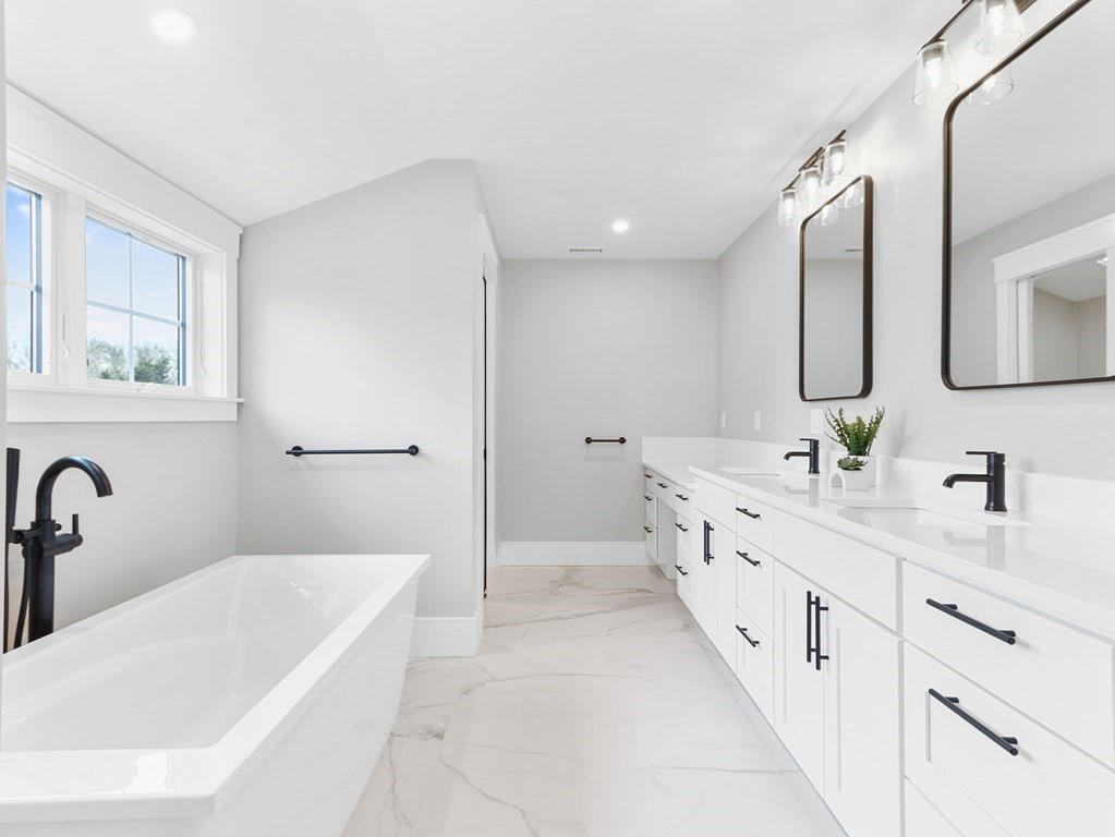 138 Lexington Street Newton, MA 02466 - Photo 14 of 27 a bathroom with a double vanity sink a mirror and a bathtub