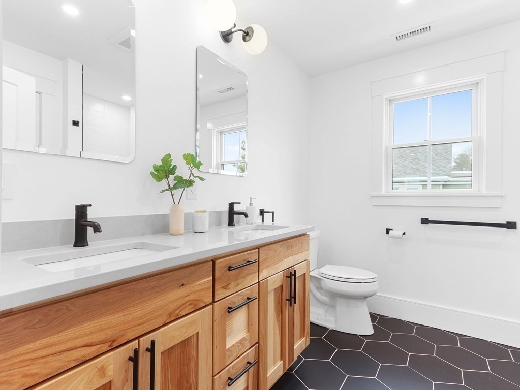 138 Lexington Street Newton, MA 02466 - Photo 17 of 27 a bathroom with a granite countertop sink mirror vanity and toilet