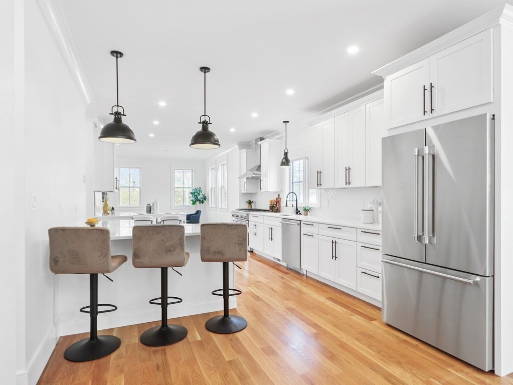 138 Lexington Street Newton, MA 02466 - Photo 6 of 27 a kitchen with stainless steel appliances kitchen island granite countertop a refrigerator a stove and white cabinets with wooden floor
