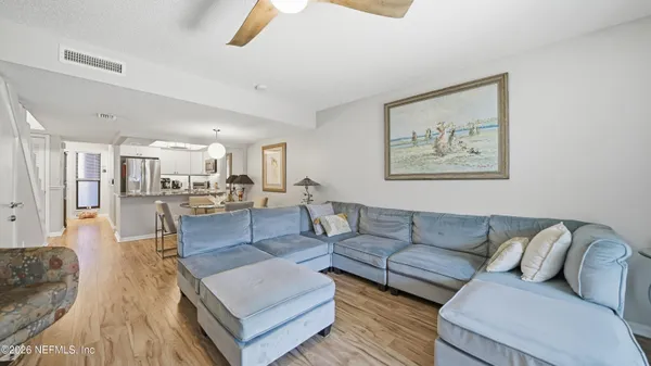 a living room with furniture and view of kitchen