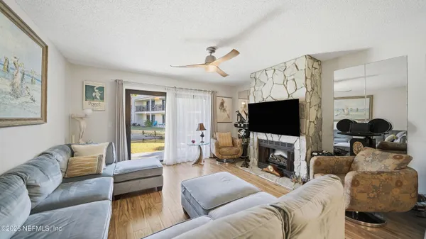 a living room with furniture a flat screen tv and a fireplace