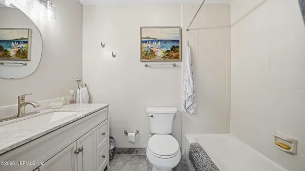 a bathroom with a granite countertop toilet sink and mirror