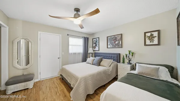 a bedroom with two beds and painting on the wall