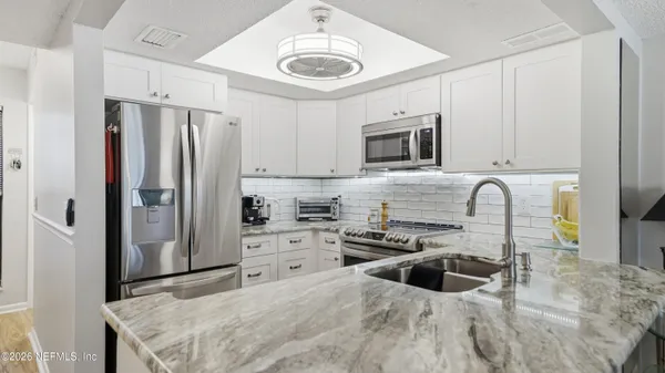 a kitchen with stainless steel appliances a stove a sink a refrigerator and cabinets