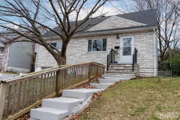 a view of a house with wooden fence next to a big yard