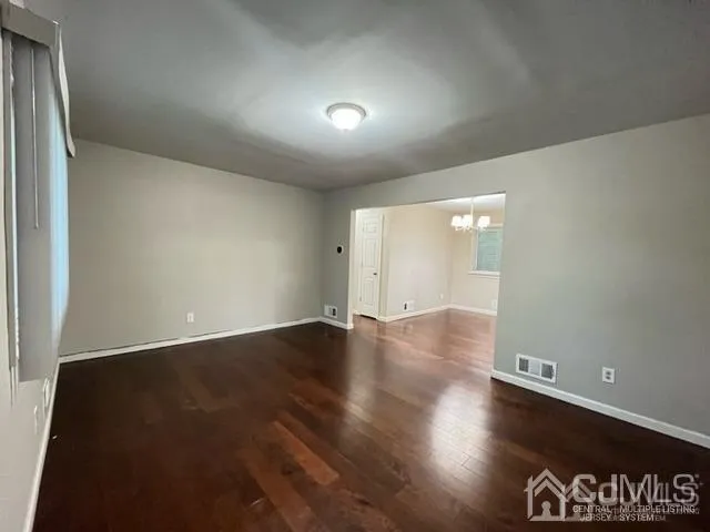 an empty room with wooden floor and closet