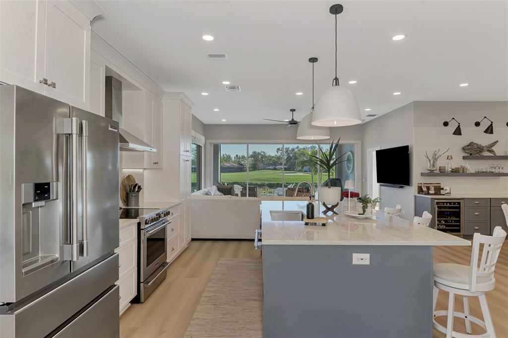 561 Fallbrook Drive Venice, FL 34292 - Photo 11 of 81 a kitchen with stainless steel appliances granite countertop a refrigerator a sink a stove and a refrigerator with wooden floor