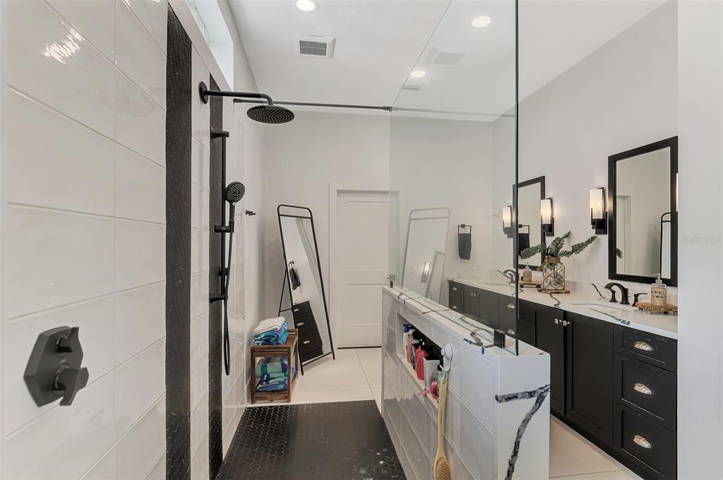 561 Fallbrook Drive Venice, FL 34292 - Photo 32 of 81 a bathroom with a double vanity sink a mirror and shower