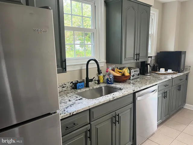 a kitchen with stainless steel appliances a refrigerator sink and cabinets