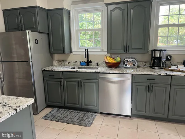a kitchen with granite countertop a stove a sink and a microwave