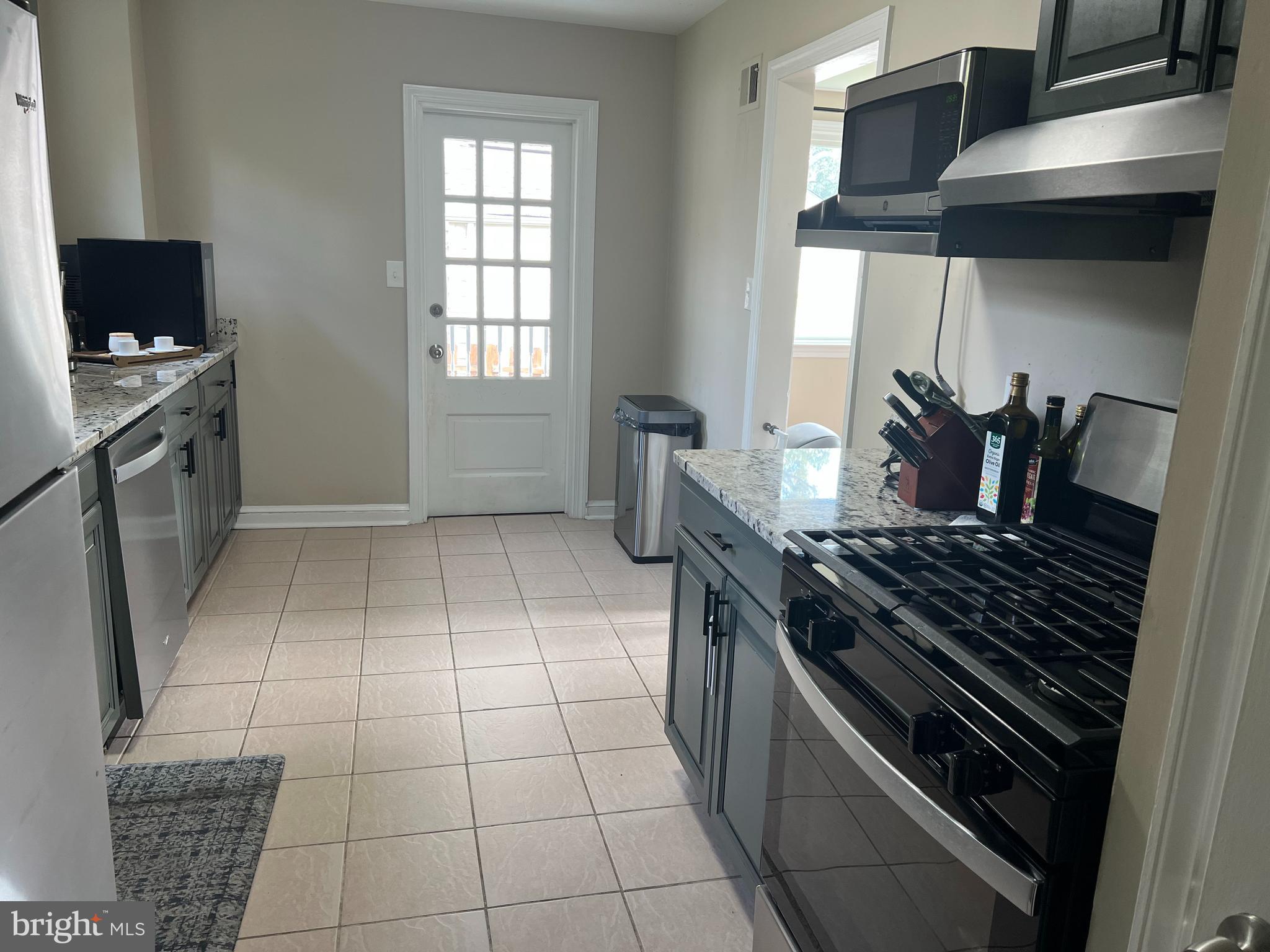 405 Gilmoure Drive Silver Spring, MD 20901 - Photo 22 of 53 a kitchen with granite countertop a stove a sink and a microwave
