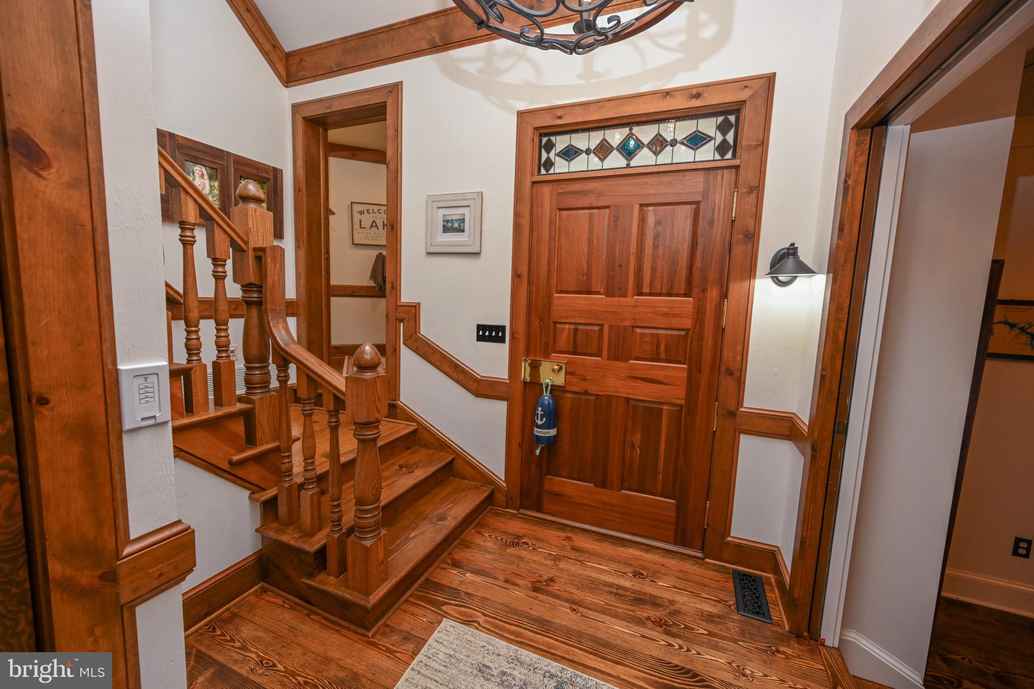 The foyer leads to the rustic beamed open living.
