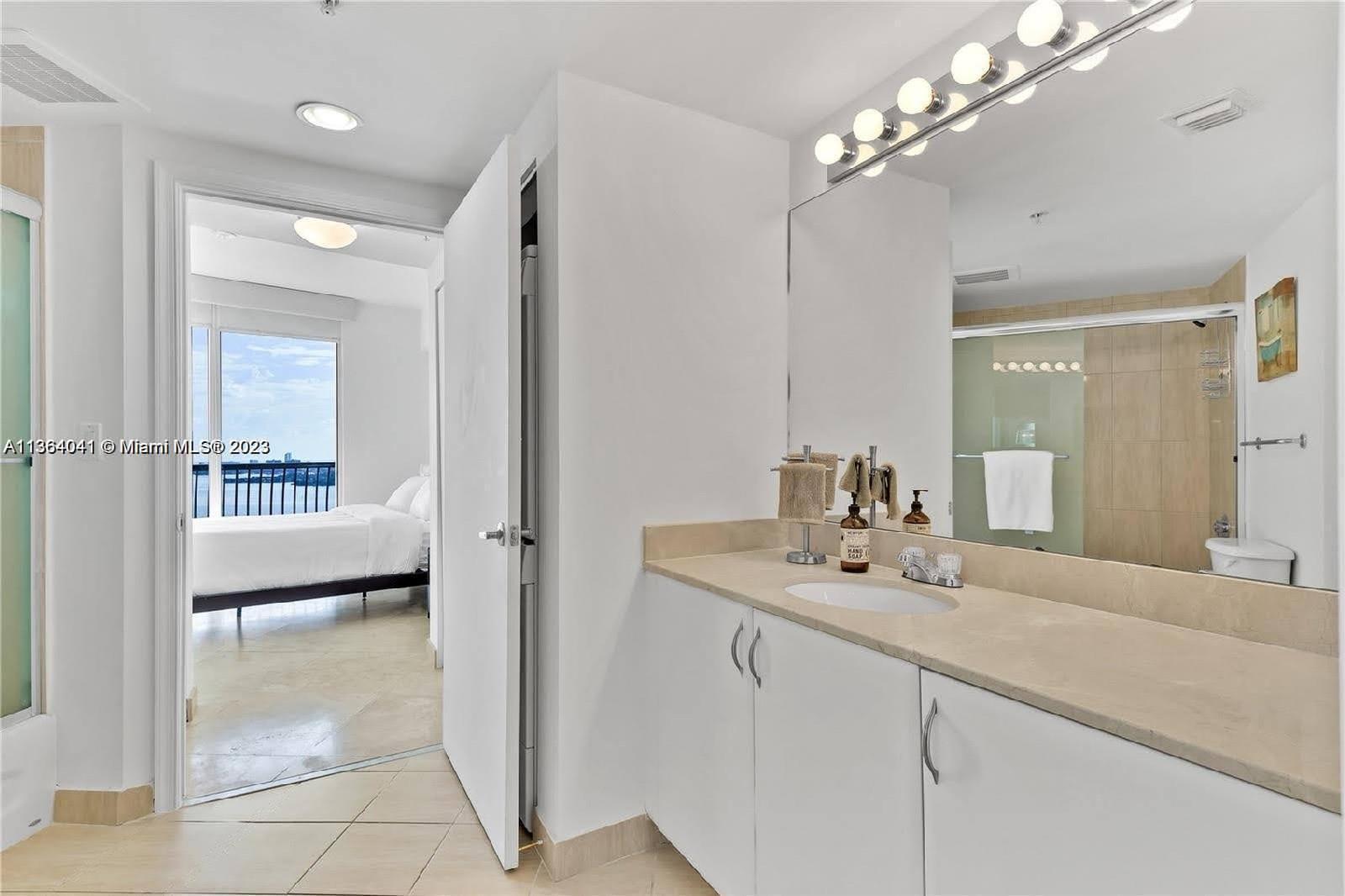 Edgewater Miami, FL 33132 - Photo 2 of 11 a bathroom with a sink a mirror and a shower