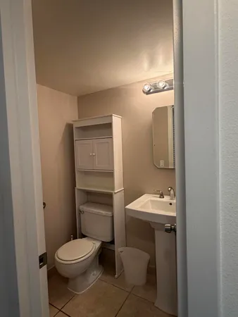 a bathroom with a toilet sink and mirror