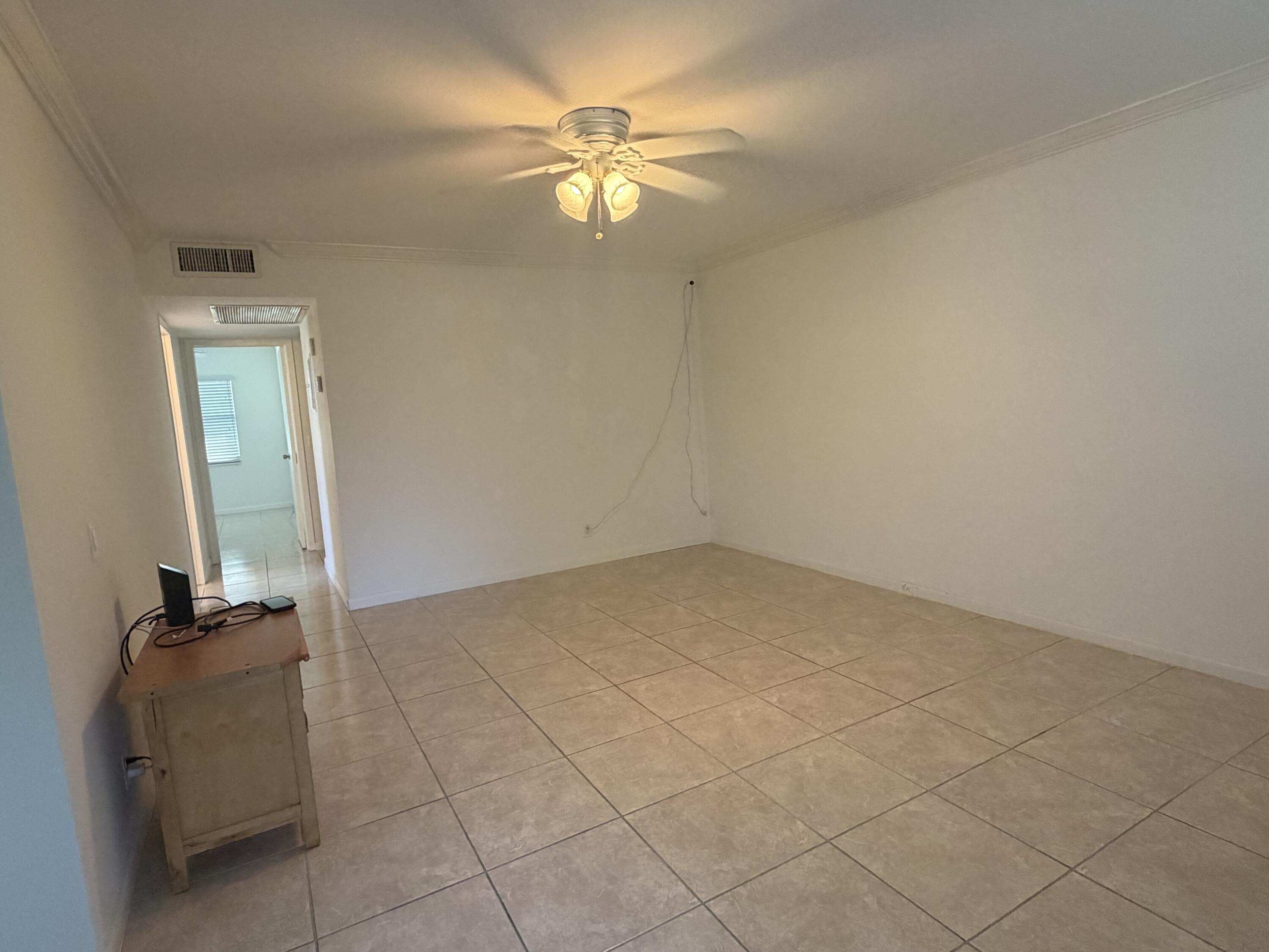 169 Suffolk F Boca Raton, FL 33434 - Photo 3 of 14 an empty room with a chandelier fan