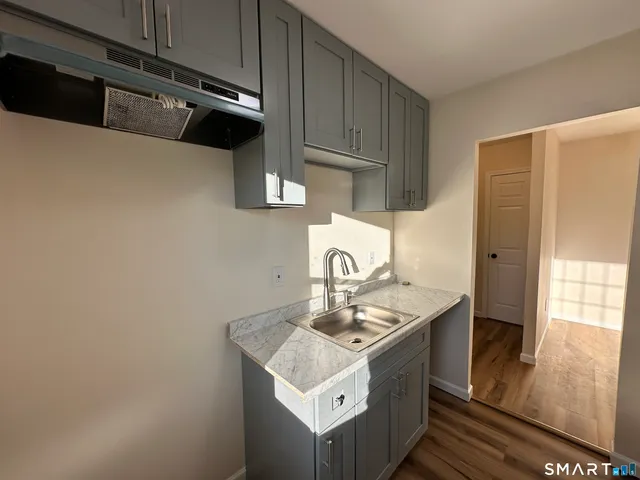 a kitchen with a sink a stove and cabinets