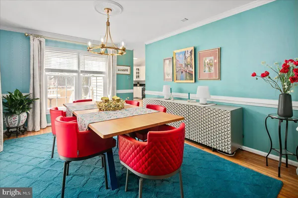 a view of a hallway with wooden floor and dining room view